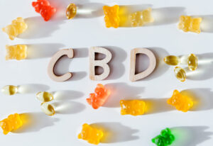 Colored gelatins, yellow capsules and letters cbd on a white background