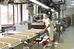 Frau bedient Maschine in der Lebensmittelindustrie – Fabrik zur