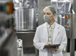 Young Woman Controlling Production at Food Factory