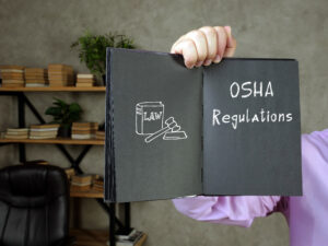 Business concept meaning OSHA Regulations with sign on the sheet.