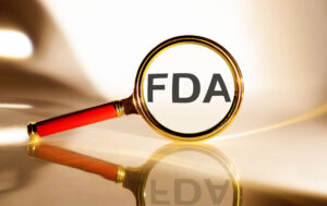 FDA concept. Magnifier glass with text on the white background in sunlight.
