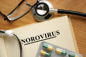 Word Norovirus  on a book and pills.
