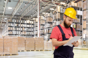 A worker writes documents in a huge distribution warehouse
