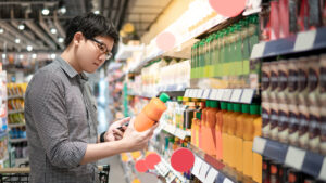 Asian man shopping orange juice using phone